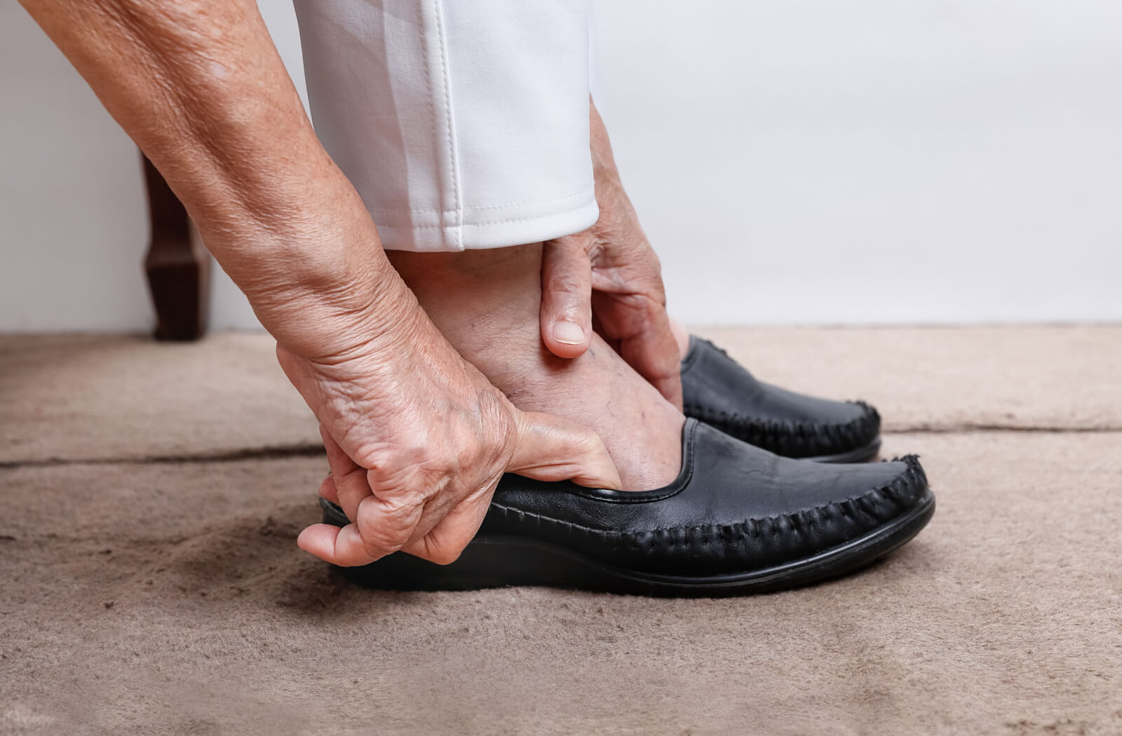 An older adult carefully adjusting their new pair of shoes.